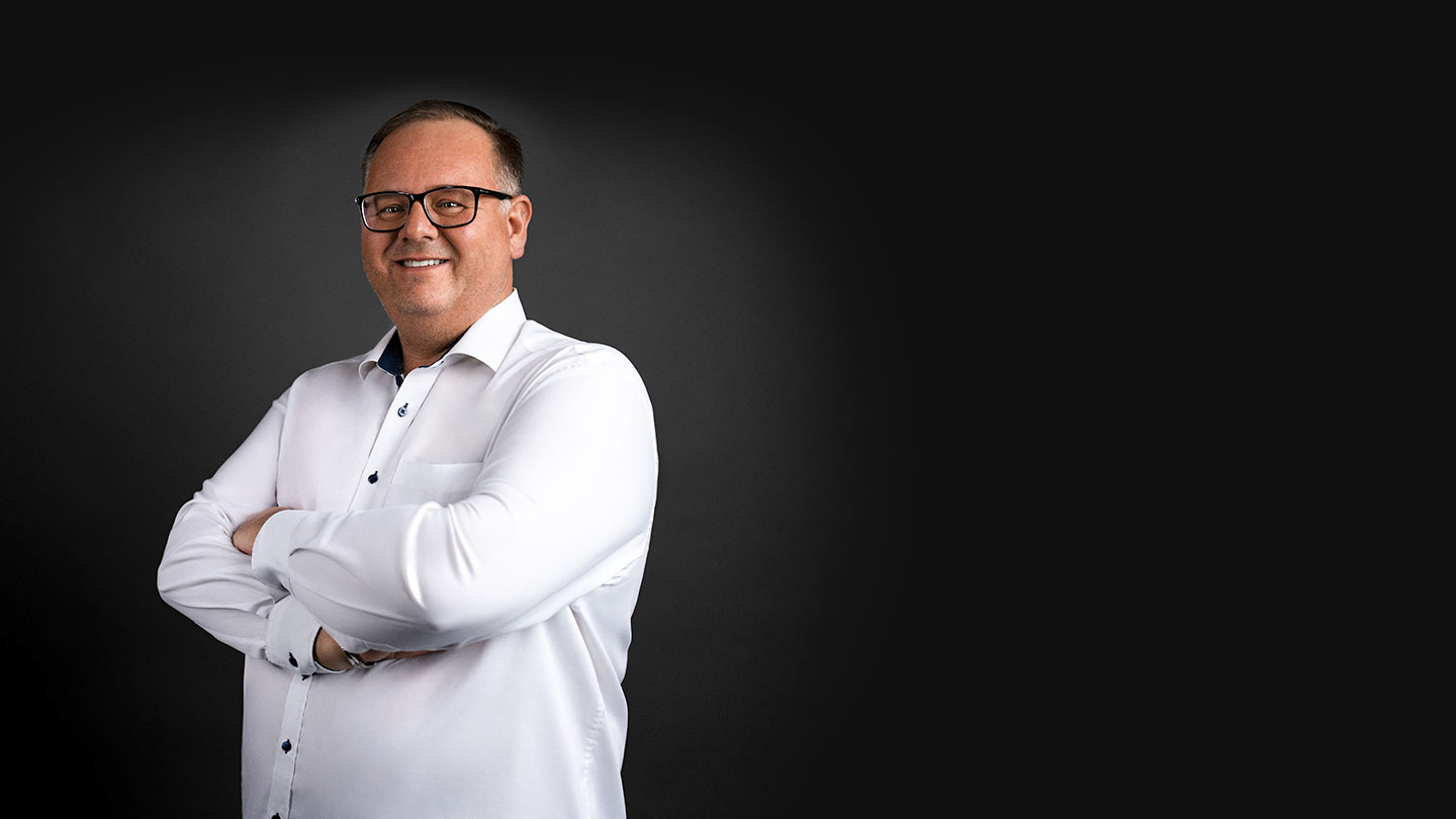 Portrait vom Geschäftsführer der ASB Group Johann Sonnleitner vor dunklem Hintergrund