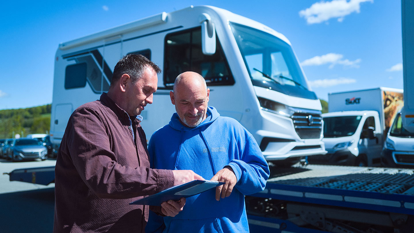 Zwei Dispositionsmitarbeiter der ASB Group unterhalten sich mit einem Fahrer