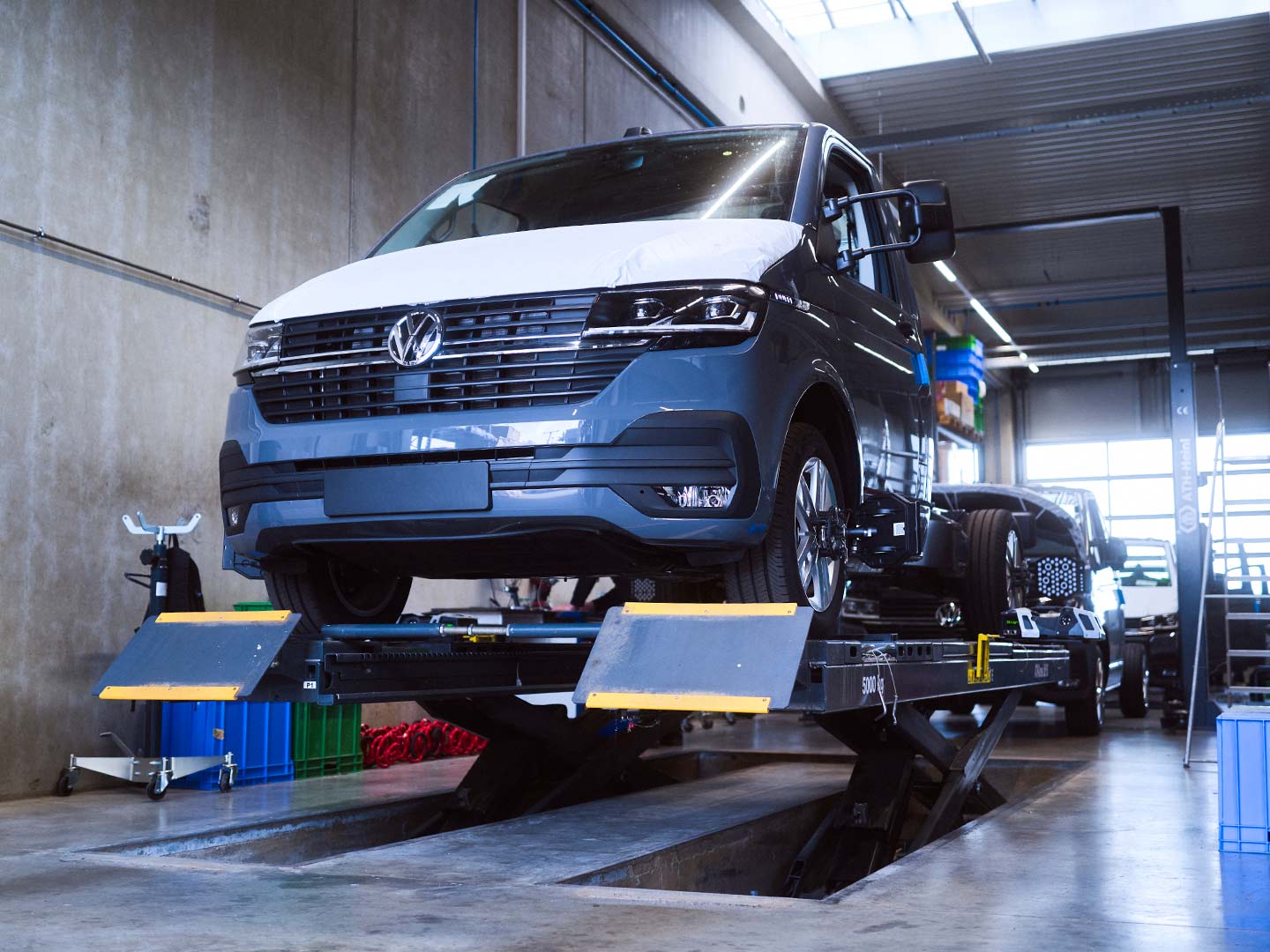 Ein Nutzfahrzeug steht auf einer Hebebühne an einer Fahrzeugaufbereitungsstraße