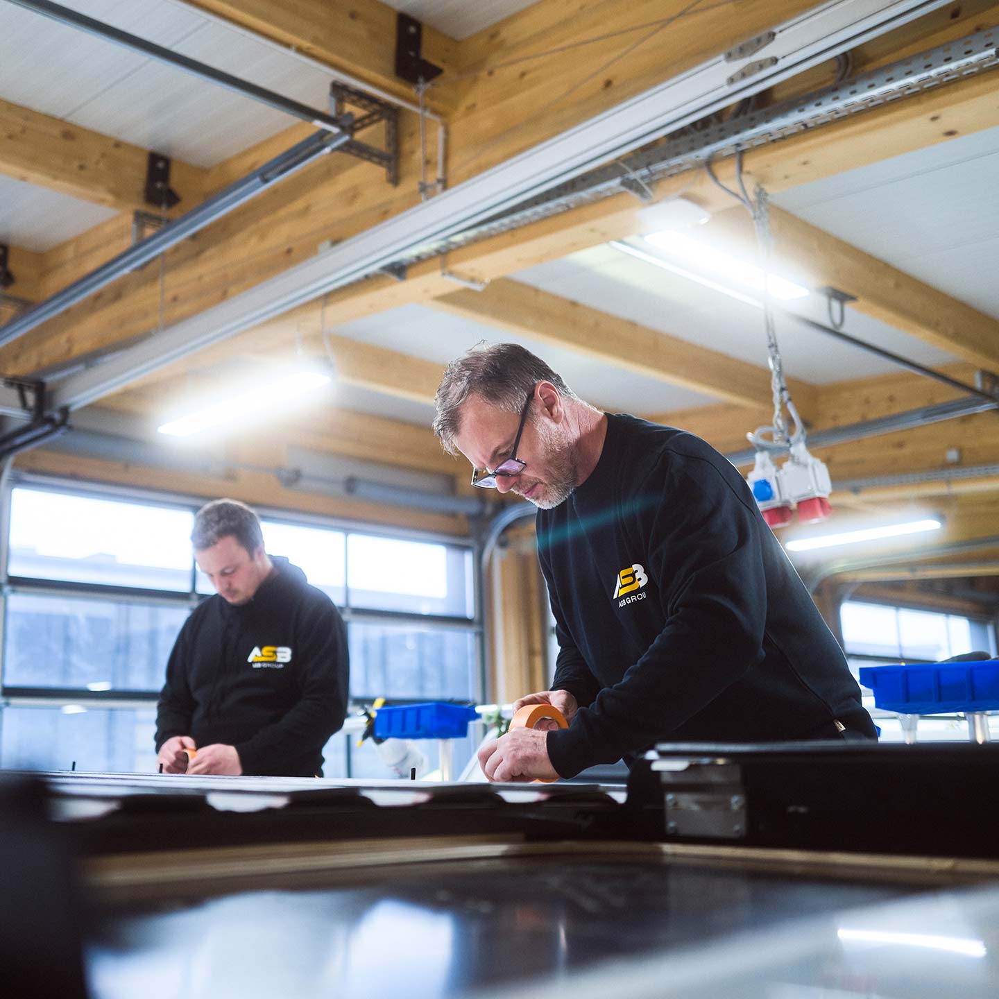 Zwei Mitarbeiter der ASB Group arbeiten am Dach eines Campingfahrzeugs