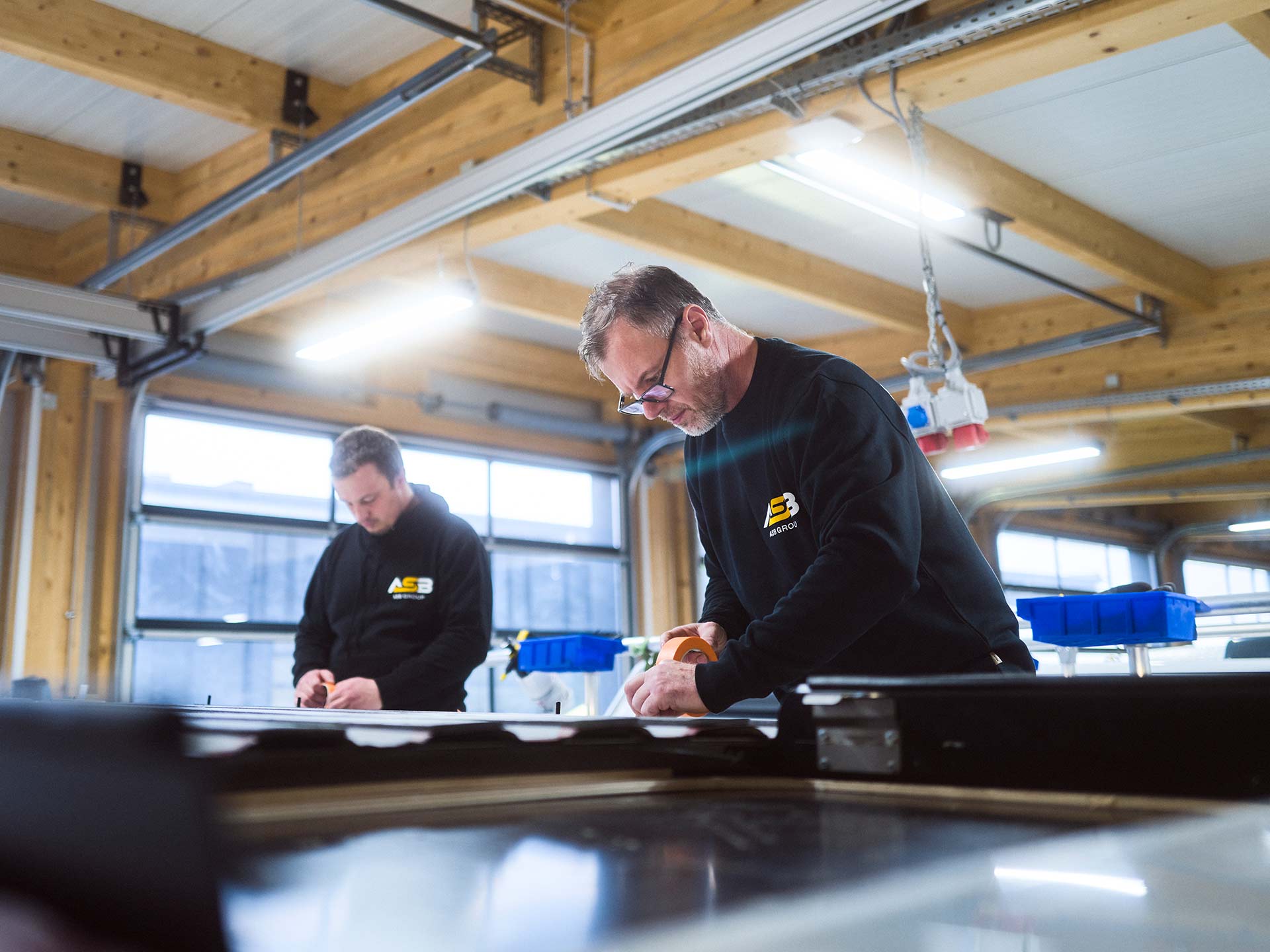 Zwei Mitarbeiter der ASB Group arbeiten am Dach eines Campingfahrzeugs