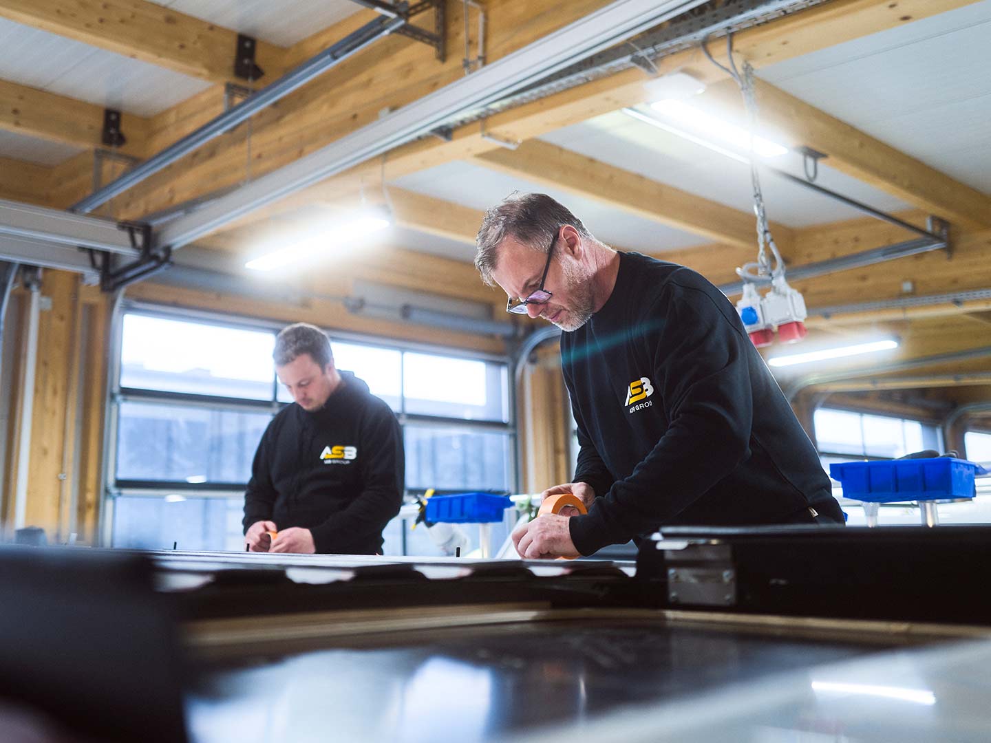 Zwei Mitarbeiter der ASB Group arbeiten am Dach eines Campingfahrzeugs