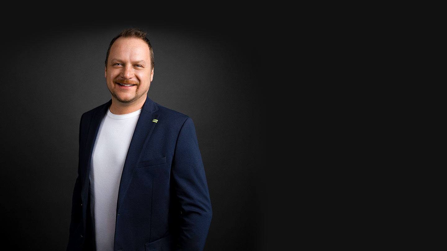 Portrait vom Geschäftsführer Christian Binder vor einfarbigem Hintergrund