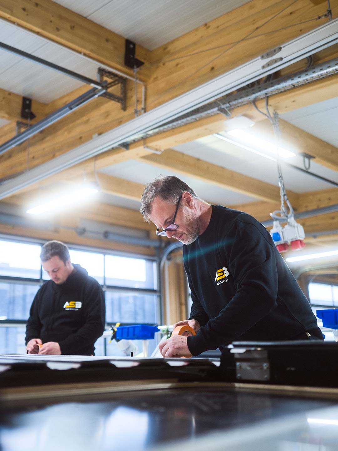 Zwei Mitarbeiter der ASB Group arbeiten am Dach eines Campingfahrzeugs