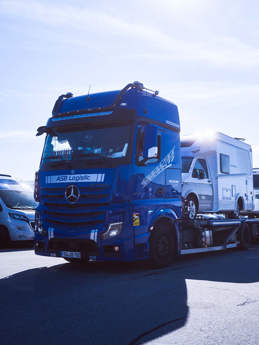 Ein LKW steht mit Campingfahrzeugen beladen auf dem Firmengelände der ASB Group