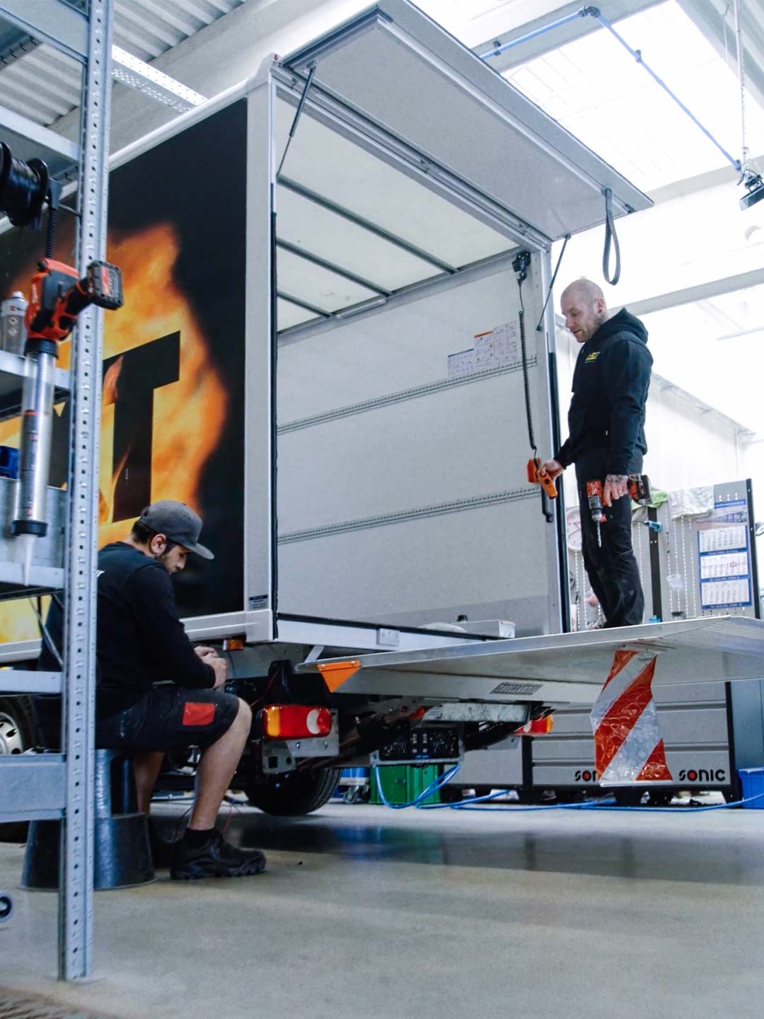 Ein Nutzfahrzeug wird in der Werkstatt der ASB Group von Mitarbeitern bearbeitet