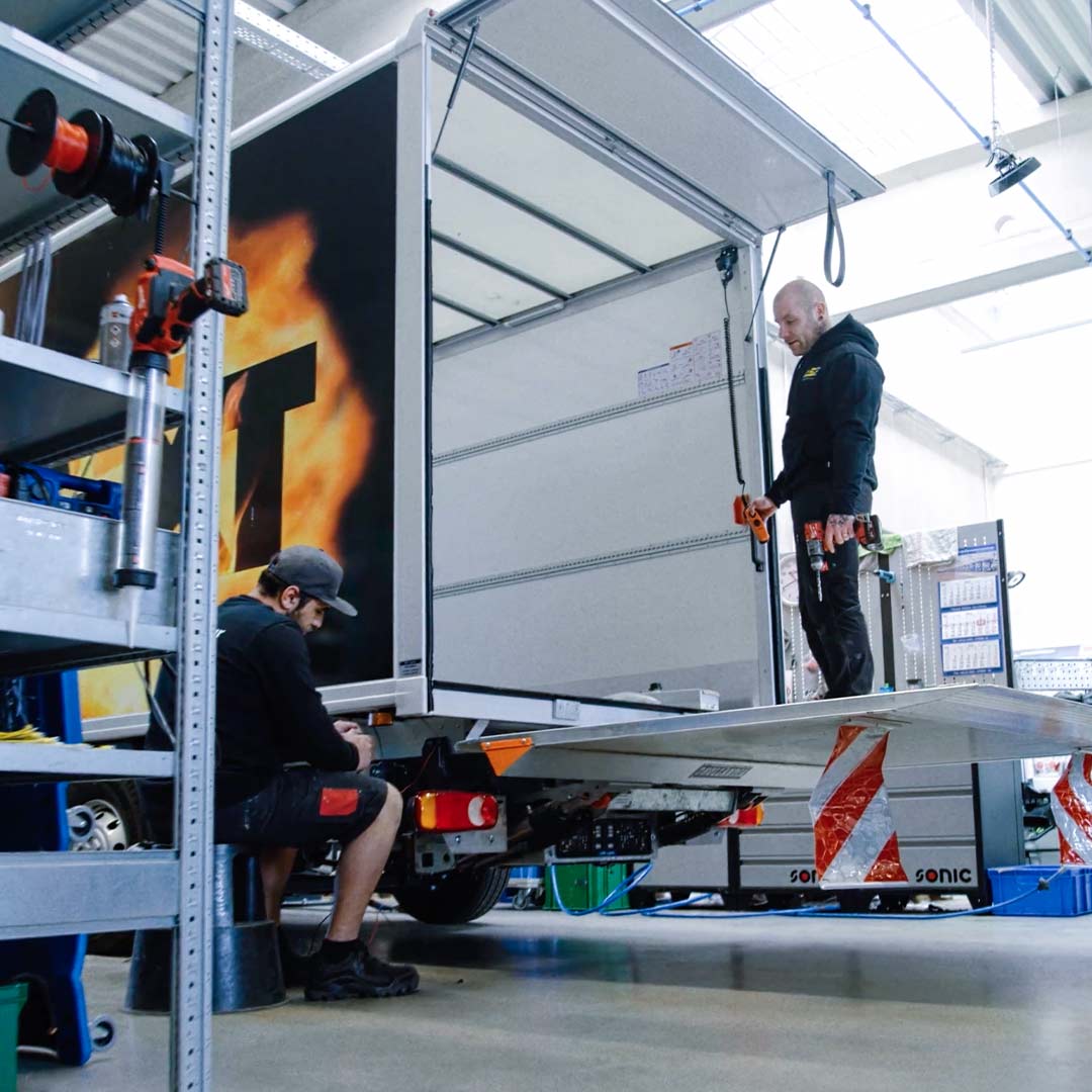 Geschäftsbereich Nutzfahrzeug Aufbaulösungen: Mitarbeiter bearbeiten ein Nutzfahrzeug in der Werkstatt