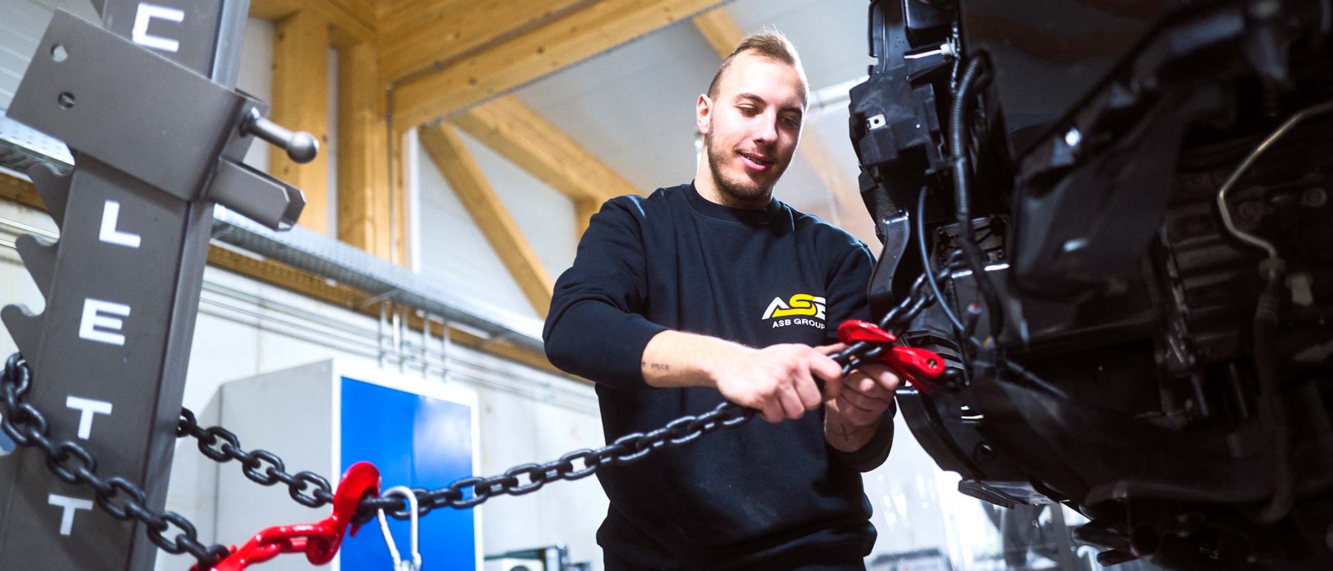 Ein Wertstattmitarbeiter der ASB Group arbeitet an der Celette Richtbank an einem PKW