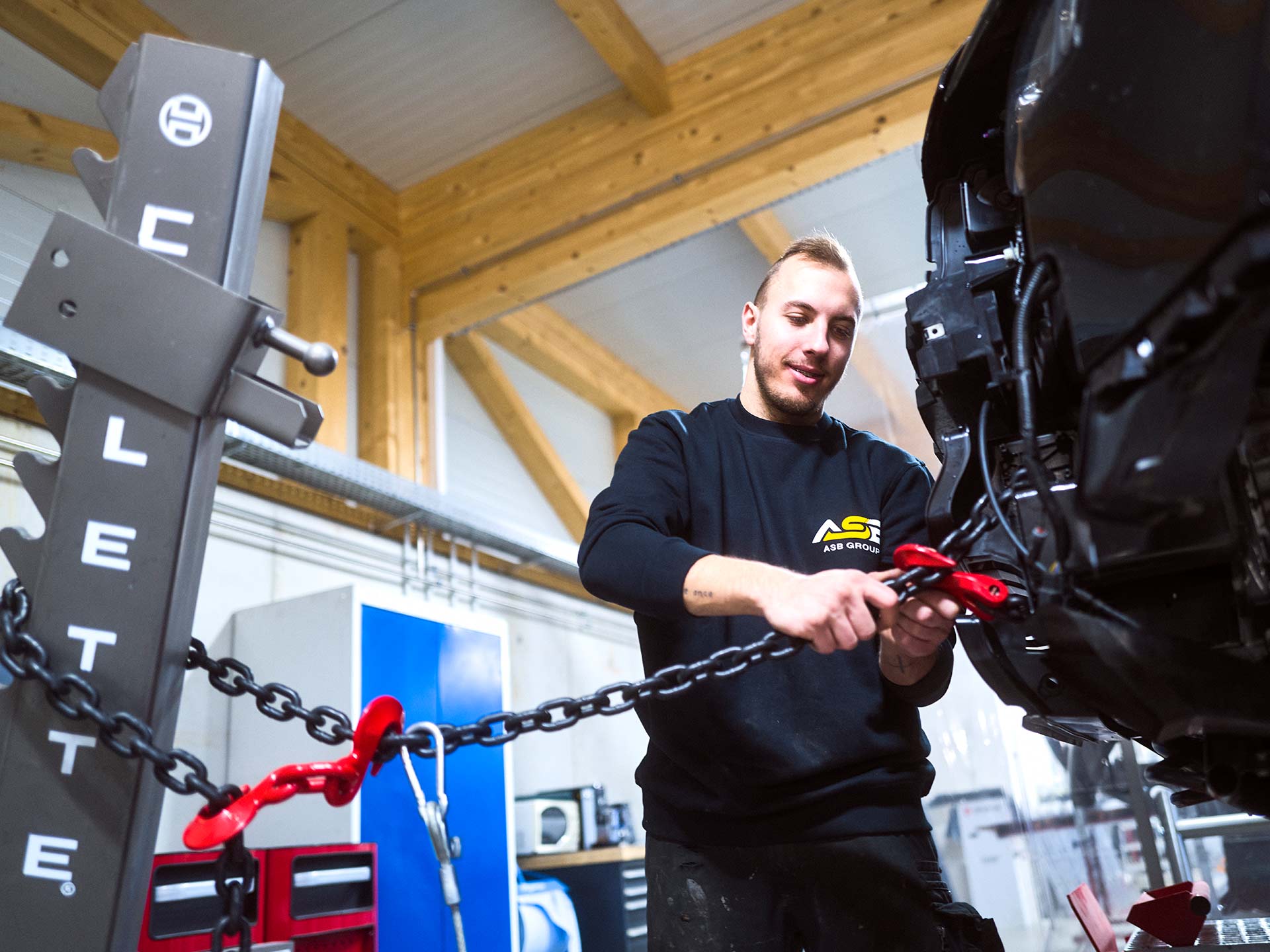 Ein Wertstattmitarbeiter der ASB Group arbeitet an der Celette Richtbank an einem PKW