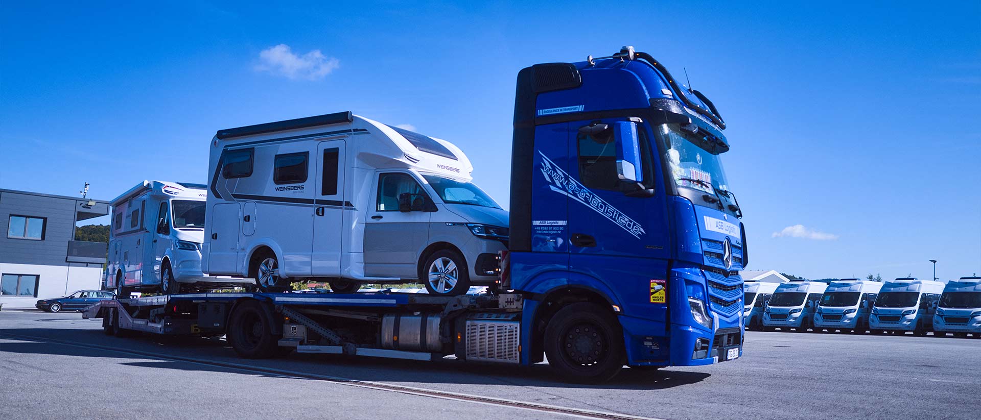 Ein LKW steht mit Wohnmobilen beladen auf dem Gelände der ASB Group