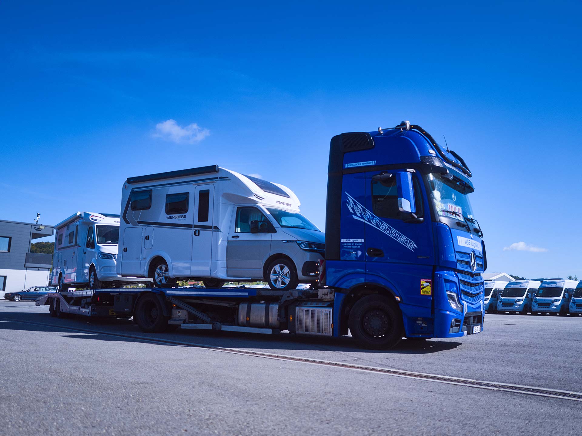 Ein LKW steht mit Wohnmobilen beladen auf dem Gelände der ASB Group