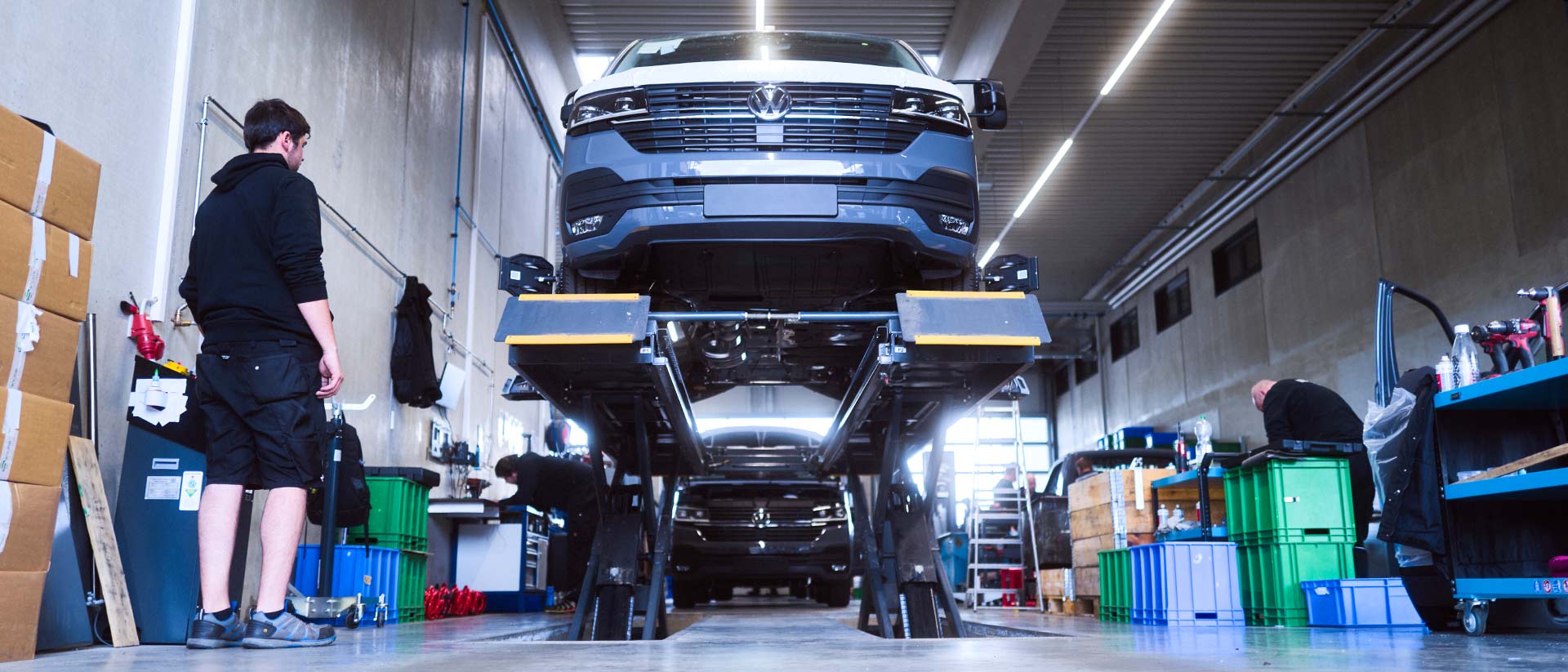 Ein Basisfahrzeug steht auf einer Hebebühne in einer Werkstatt der ASB Group