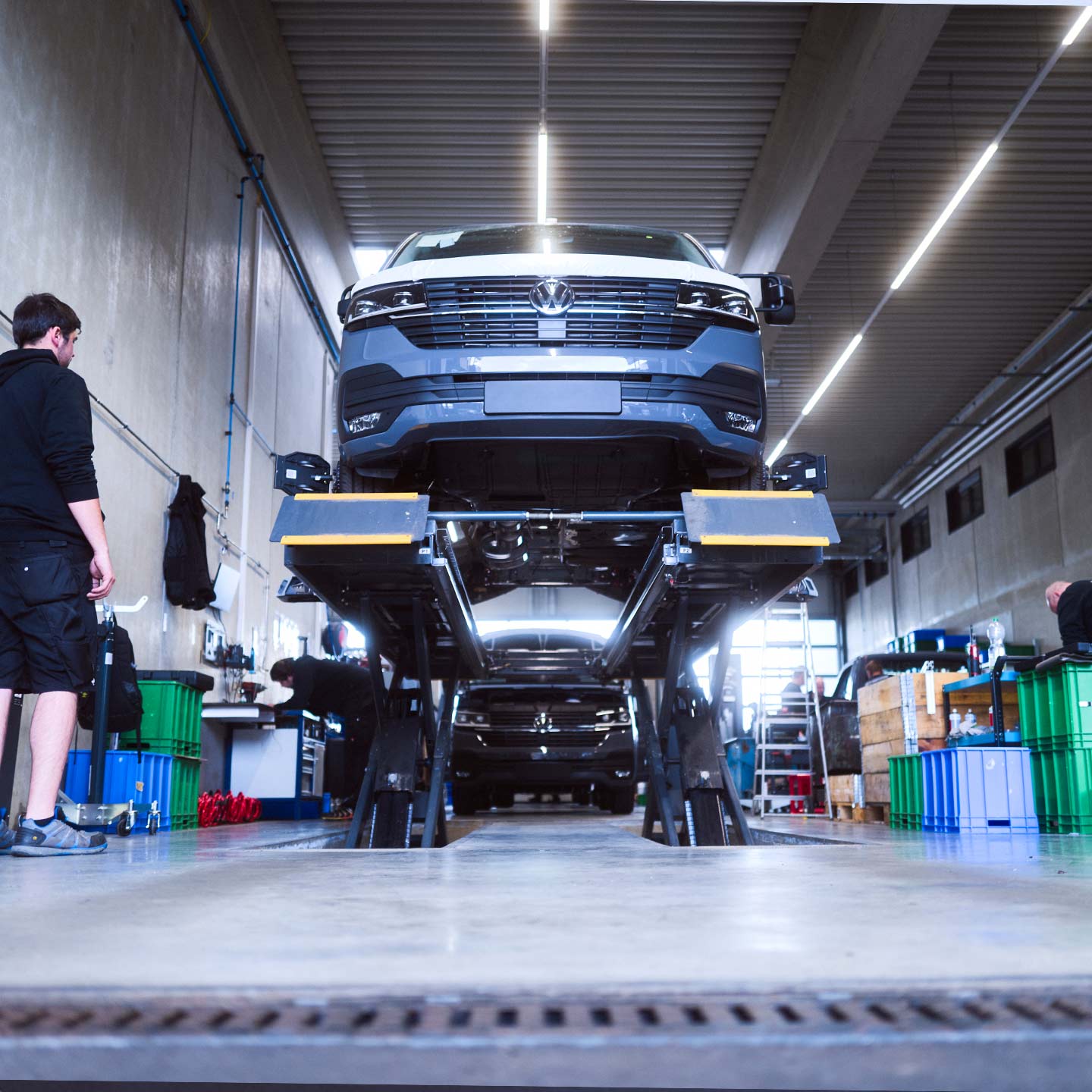 Ein Basisfahrzeug steht auf einer Hebebühne in einer Werkstatt der ASB Group