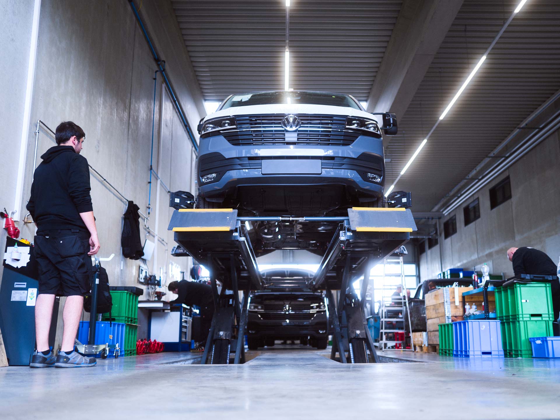 Ein Basisfahrzeug steht auf einer Hebebühne in einer Werkstatt der ASB Group